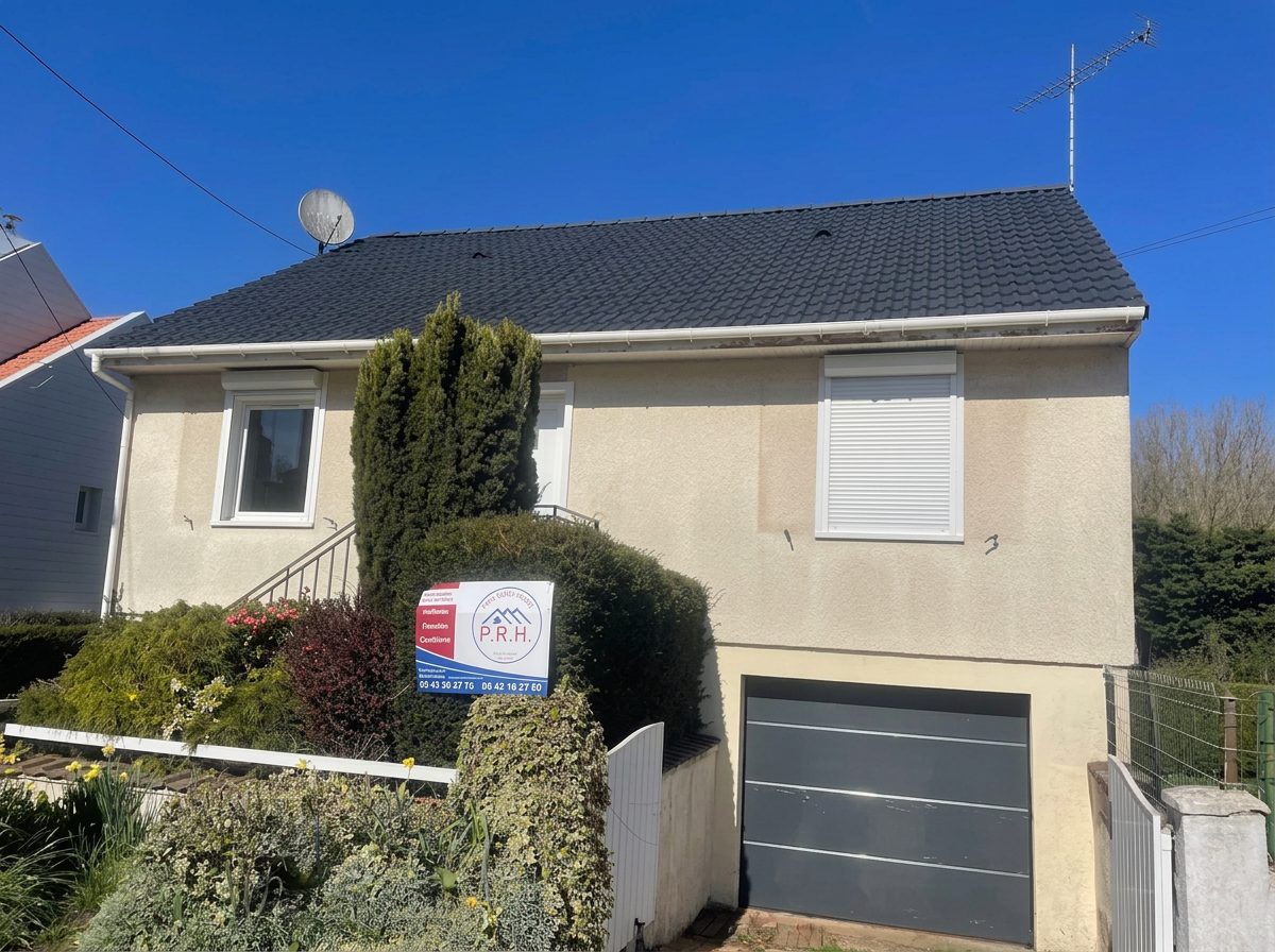 Panneau Pro Réno Home planté devant une maison beige au toit sombre, sous un ciel bleu