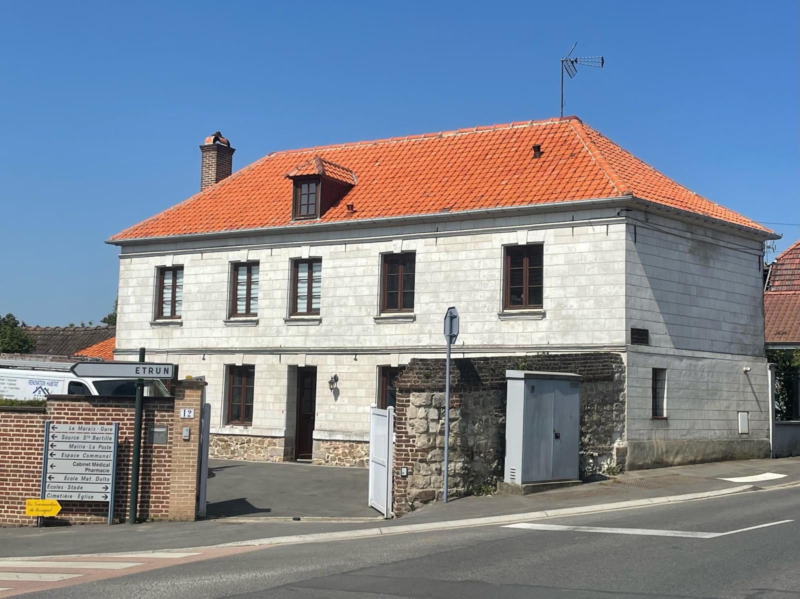 Maison en pierre à Étrun à la façade claire et à la toiture éclatante après le nettoyage, sous un ciel bleu